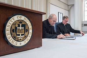 Rev. John Jenkins, C.S.C., and Archbishop Carlos Aguiar Retes, archbishop of Tlalnepantla, Mexico, and president of the Latin American Bishops' Conference (CELAM), sign a Memorandum of Understanding