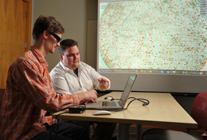 Graduate students Anthony Strathman and Ryan Lichtenwalter work with a 3-D visualization of cell phone networks.