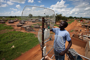 An employee of BOSCO Uganda adjusts an antenna